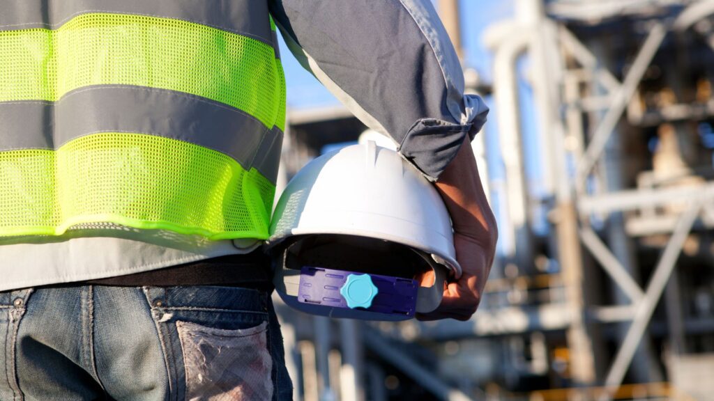 Industrial worker holding a hard hat 